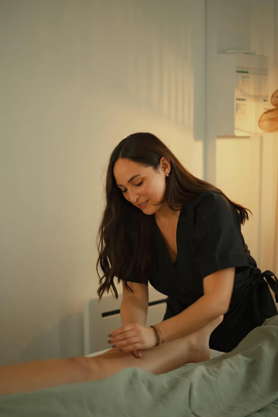 Constance sourit en réalisant un drainage de la jambe